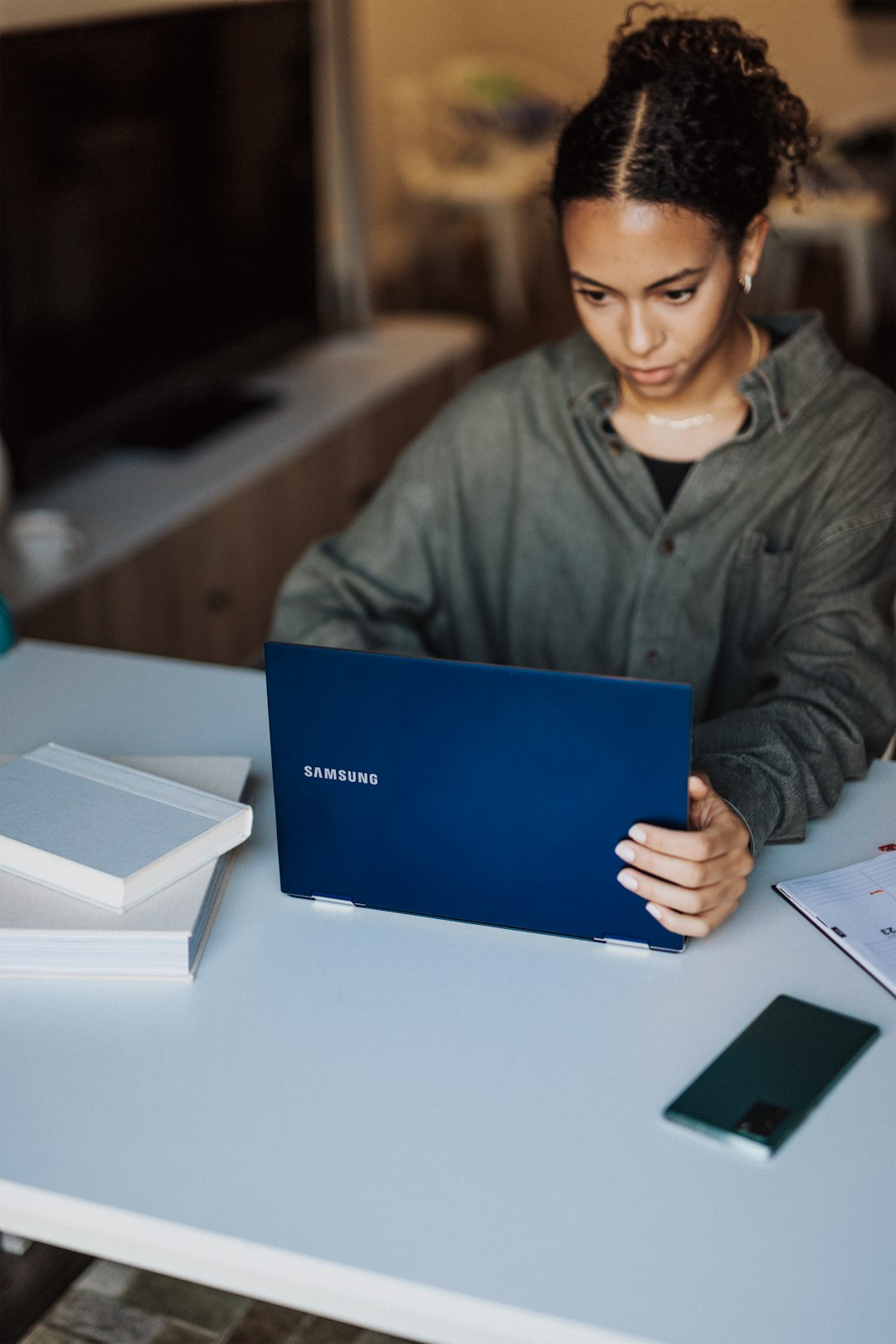 woman-in-gray-jacket-holding-blue-laptop-j5cexgcjb8a